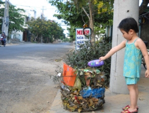 Hành động bỏ rác thải sinh hoạt đúng nơi quy định để giữ gìn môi trường sạch đẹp của 1 cháu bé thật đáng khen - Ảnh: T.THÀNH