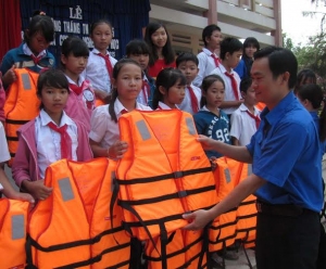 Anh Đinh Tấn Lực trao tặng áo phao cho các em học sinh Trường THCS Huỳnh Thúc Kháng (huyện Tuy An)