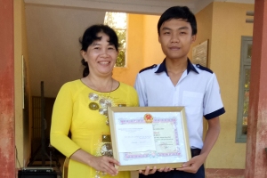 Cô Huỳnh Thị Thúy Diễm trao giấy khen học sinh xuất sắc nhất trường năm học 2016-2017 cho em Lê Khánh Huy.