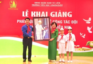 Chủ tịch Hội đồng Đội Trung ương Nguyễn Ngọc Lương trao tặng nhà trường bức tranh Bác Hồ quàng khăn đỏ cho thiếu nhi