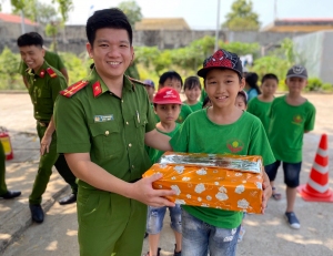 Thượng úy Lê Thanh Nhâm tặng quà cho các em thiếu nhi tại chương trình trải nghiệm “Chúng em là lính cứu hỏa”