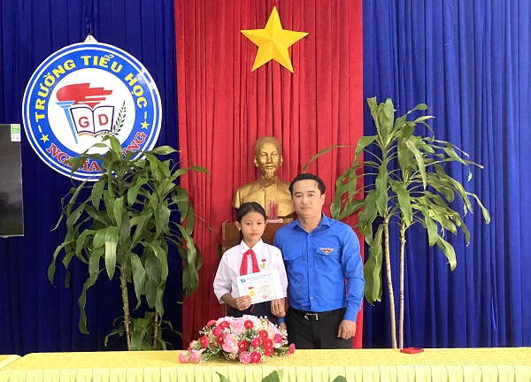 Anh Đỗ Duy Nam, Phó BT tỉnh đoàn Gia Lai trao huy hiệu tuổi trẻ dũng cảm cho em Rơ Chăm Ư