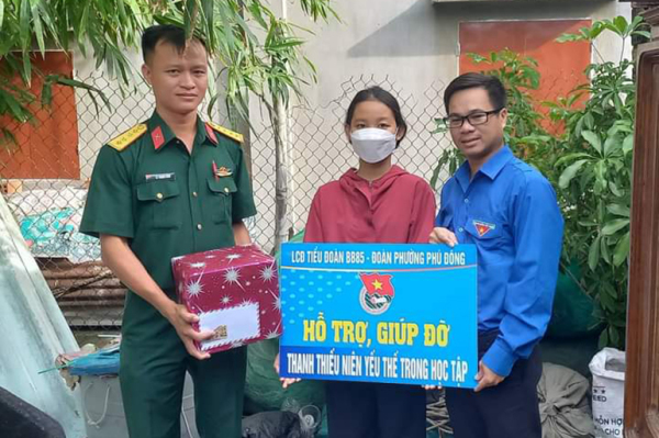 Huỳnh Quốc Toàn (bìa phải) trao quà hỗ trợ, giúp đỡ thanh thiếu niên yếu thế trong học tập. Ảnh: CTV