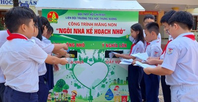 Học sinh, đội viên Trường tiểu học Trưng Vương bỏ chai nhựa và giấy vụn vào Ngôi nhà kế hoạch nhỏ. Ảnh: NGỌC HÙNG