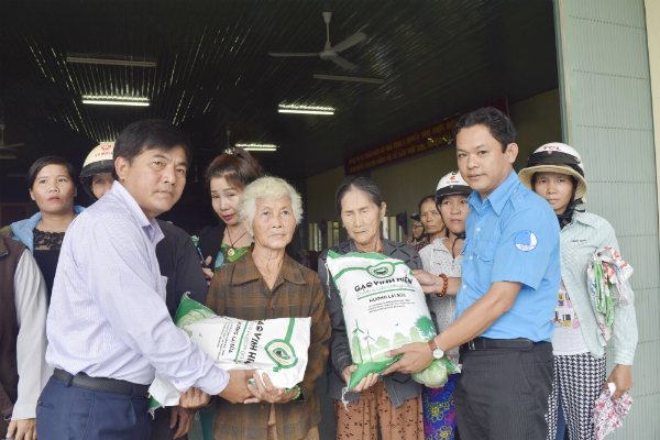 Anh Phan Xuân Hạnh - Phó Bí thư Thường trực Tỉnh Đoàn, Chủ tịch Hội LHTN Việt Nam tỉnh và anh Trương Thanh Tâm, đại diện Công ty TNHH Thiên Ngọc Minh Uy trao gạo cho bà con vùng lũ xã Hoà Thành (H.Đông Hòa).