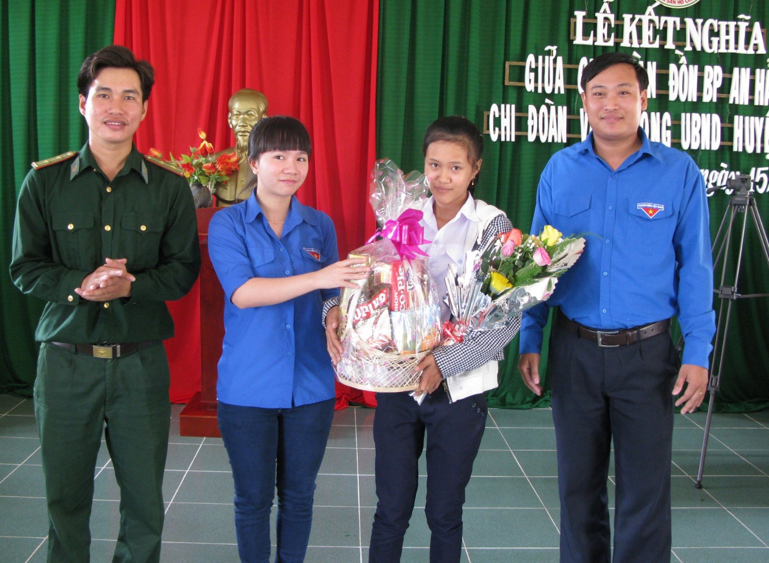 Anh Phan Đức Tài (bên phải) tặng quà cho học sinh nghèo tại địa phương.