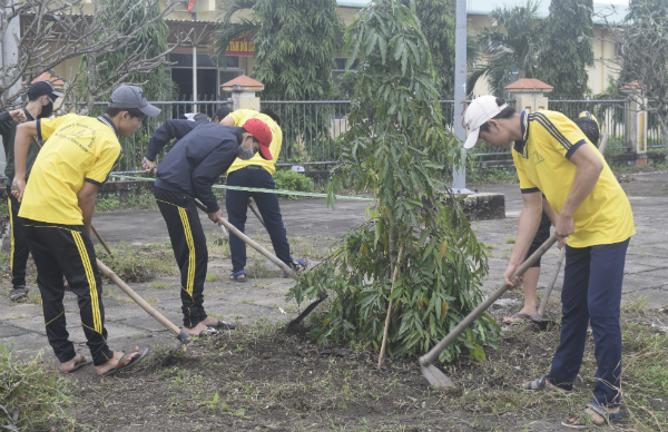 Các em học sinh trường THPT Nguyễn Thị Minh Khai dọn vệ sinh tại khu vực đoạn đường Quốc lộ 29 đi qua thị trấn Phú Thứ.