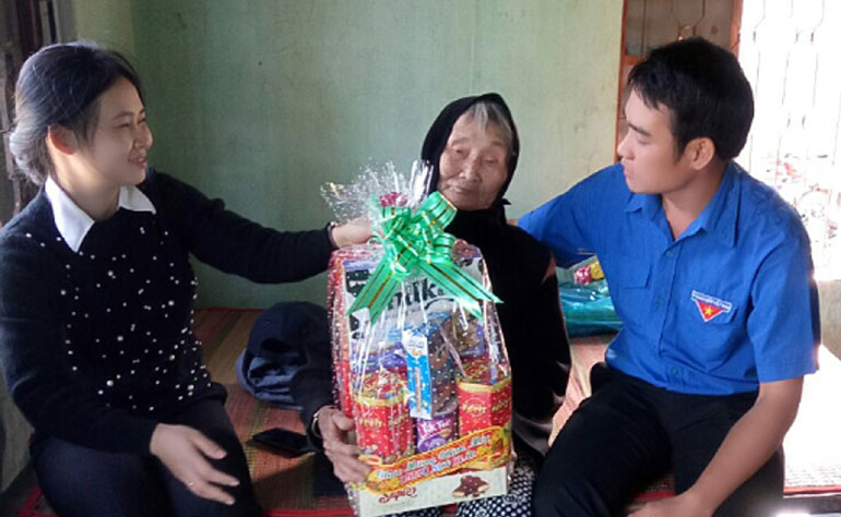 Huỳnh Quốc Đại (bìa phải) tặng quà cho một gia đình chính sách trong xã.