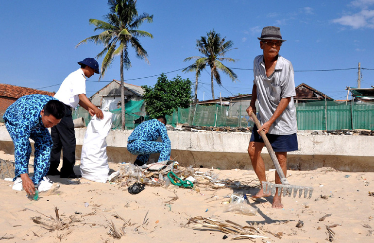 Ông Nguyễn Khô (phải) tham gia làm sạch bãi biển