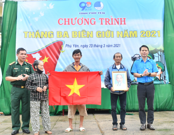Anh Lương Minh Tùng- Phó Bí thư Tỉnh Đoàn, Chủ tịch Hội LHTN Việt Nam tỉnh và Bộ Chỉ huy Biên phòng tỉnh trao tặng cờ Tổ quốc và ảnh chân dung Bác Hồ cho ngư dân.