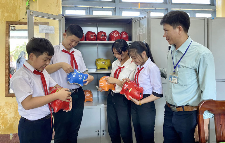 Đội viên Trường THCS Nguyễn Thị Định (huyện Tây Hòa) hào hứng cho heo đất “ăn”.