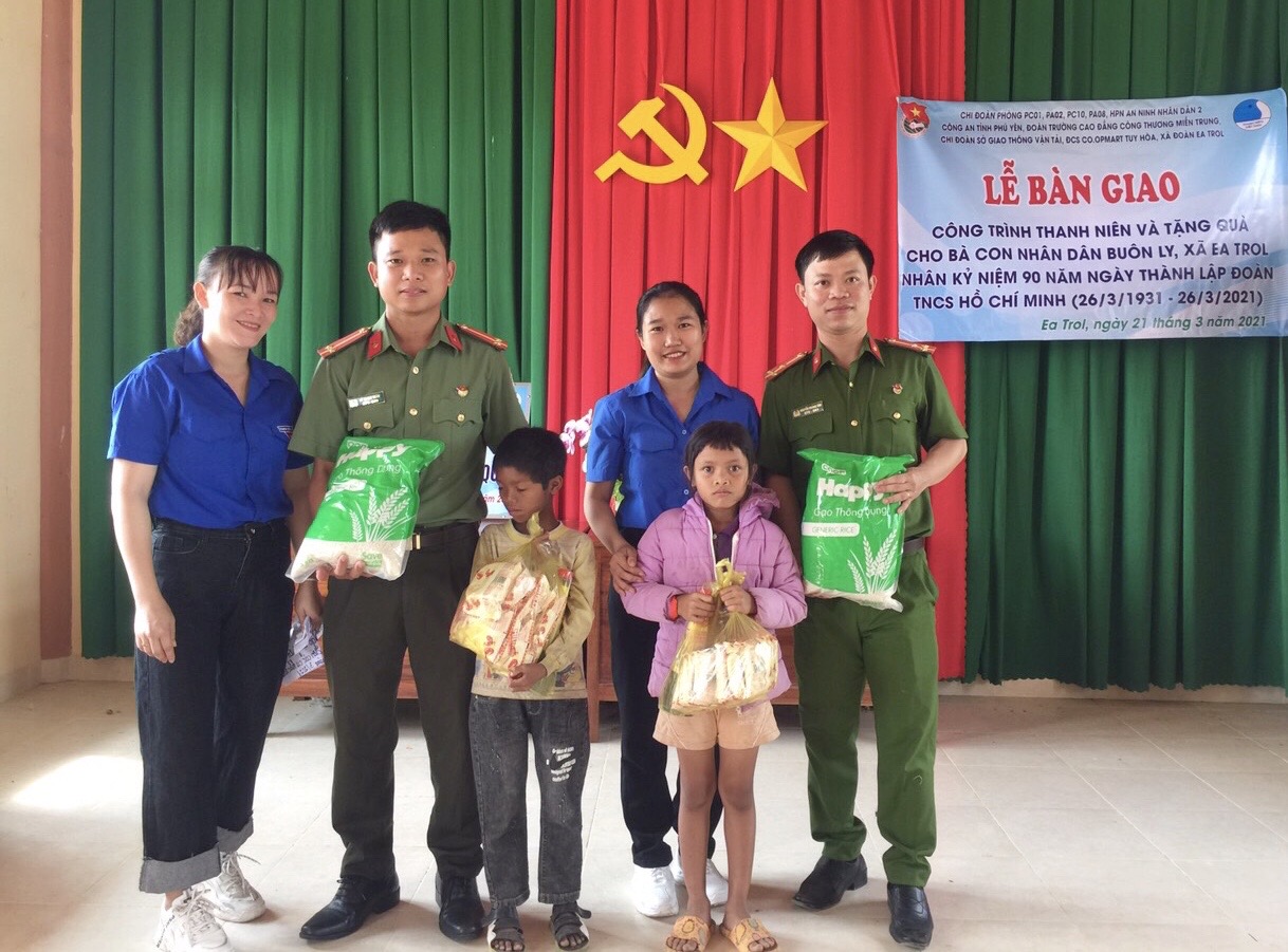 Thượng úy Nguyễn Hoàng Tâm (phải) tặng quà cho trẻ em khó khăn tại buôn Ly, xã Ea Trol, huyện Sông Hinh