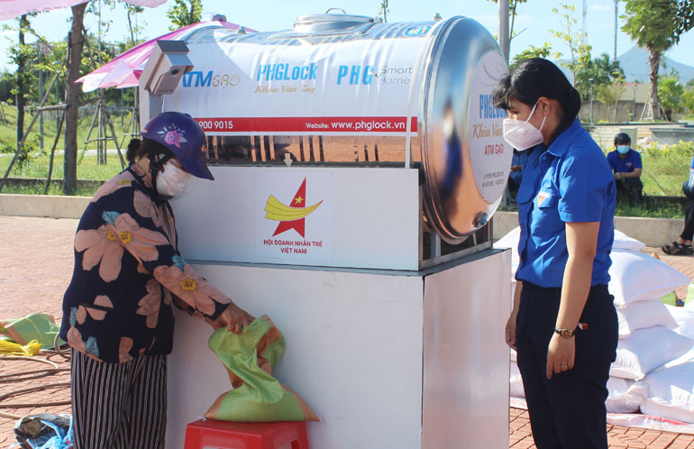 Bà Dương Thị Thúy được đoàn viên thanh niên hướng dẫn “rút gạo” từ ATM gạo.