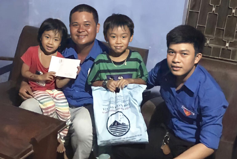 Lê Tấn Ninh (bìa phải) tặng quà cho thiếu nhi có hoàn cảnh khó khăn.