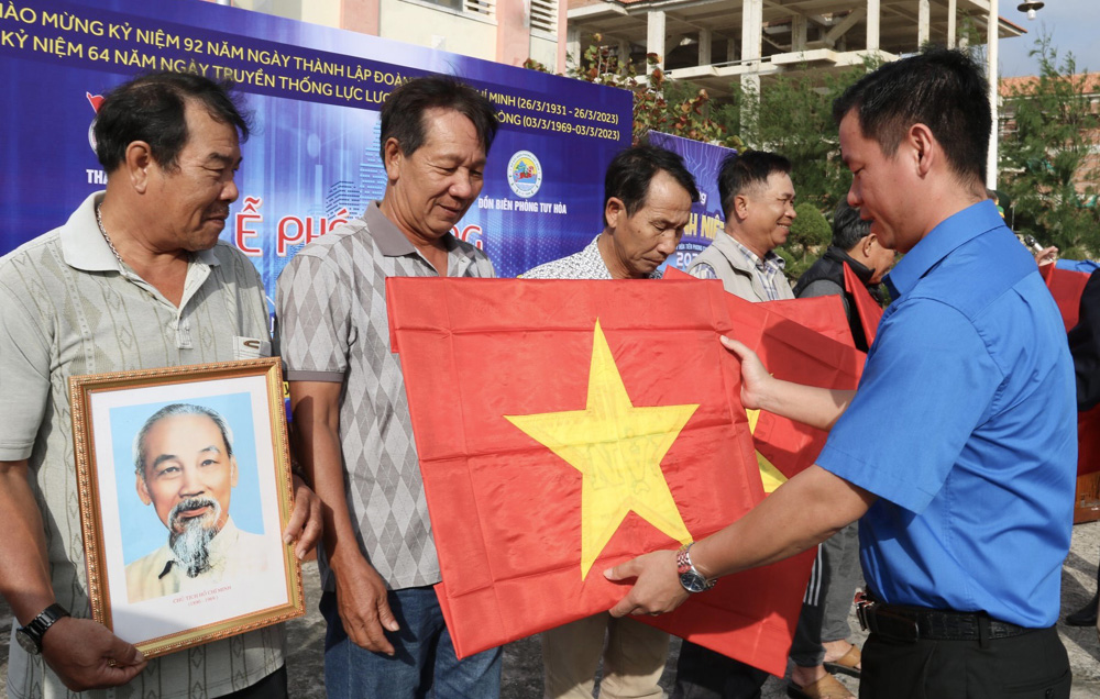 Phó Bí thư Tỉnh đoàn Võ Duy Kha tặng cờ Tổ quốc và ảnh Bác Hồ cho ngư dân TP Tuy Hòa. Ảnh: HÀ MY