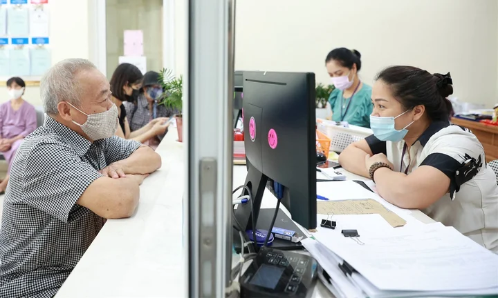 Công chức phường ở Hà Nội hỗ trợ người dân giải quyết thủ tục hành chính.